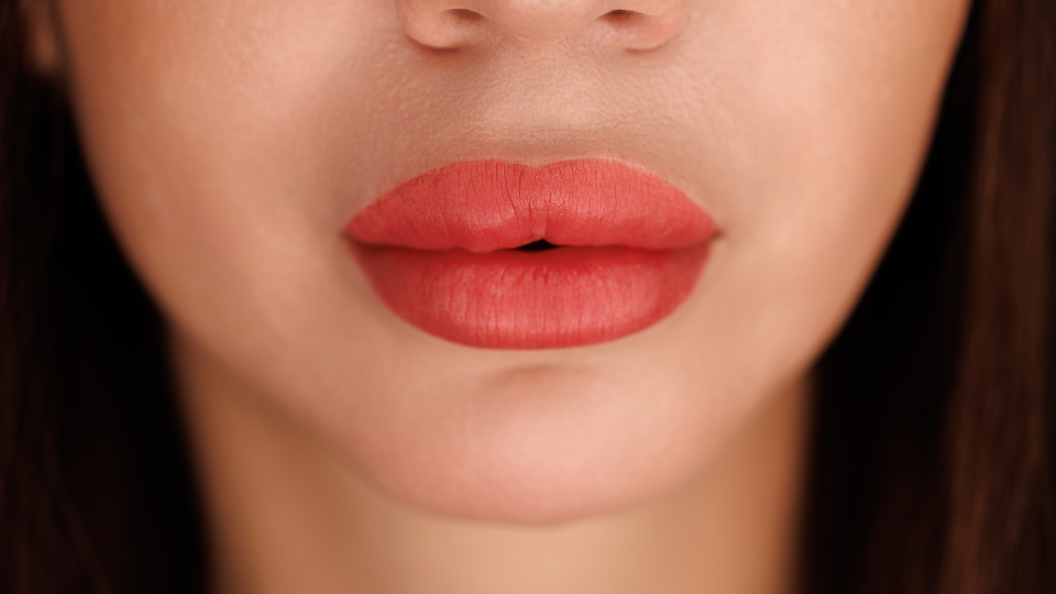 Close-up of red lips with smooth texture and defined cupid's bow; references injectable aesthetics with BOTOX, Dysport, Jeuveau.